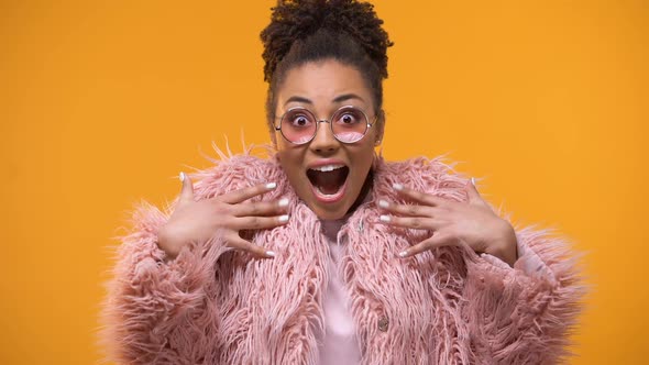 Extremely Happy Woman Amazed at Fashion Trends, Millennials, Yellow Background