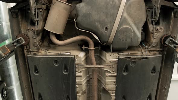 Auto mechanic working underneath car lifting machine at the garage. Auto repair 