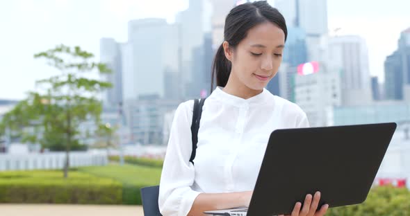 Business woman use of notebook computer at city