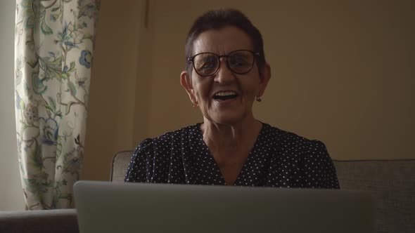 Smiling Senior Woman Sitting at Home Office Workplace Looking in Laptop