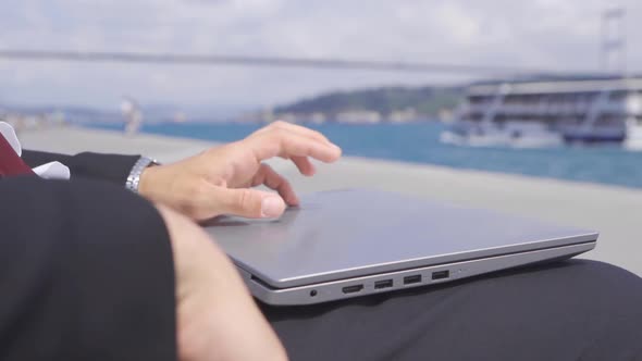 Thoughtful businessman opens his laptop and works. Slow motion.