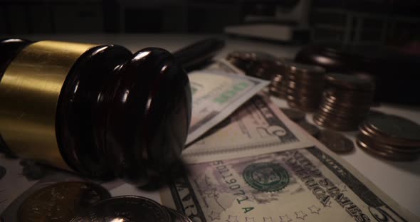 Judge Gavel Dollars and Coins on Table