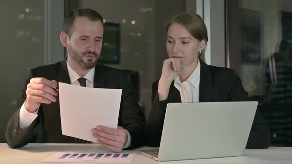 Executive Business People Reading Documents Report at Night