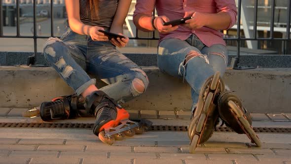 Couple on Rollerblades Sitting.