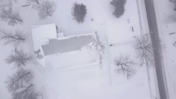 Birds eye drone footage over a small town during a blizzard