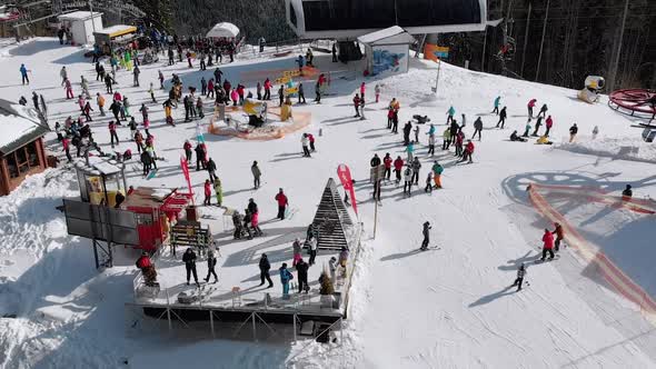 Aerial View Crowd of Skiers Skiing on Peak Ski Slope Near Ski Lifts. Ski Resort