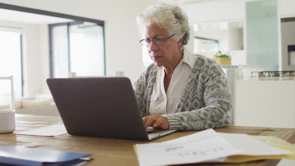 Thoughtful african american senior woman using laptop at home