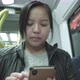 Front view of Asian woman sitting and using smartphone on a train - VideoHive Item for Sale