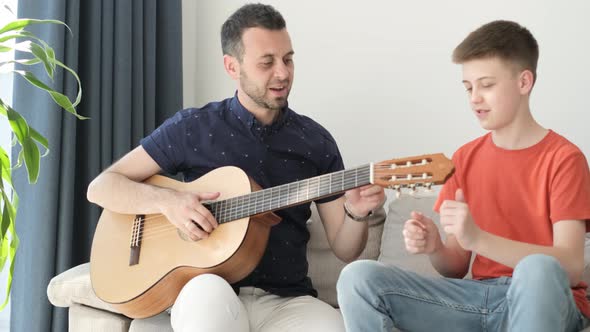 Dad Teaches His Son to Play the Guitar a Family of Musicians a Stringed Musical Instrument