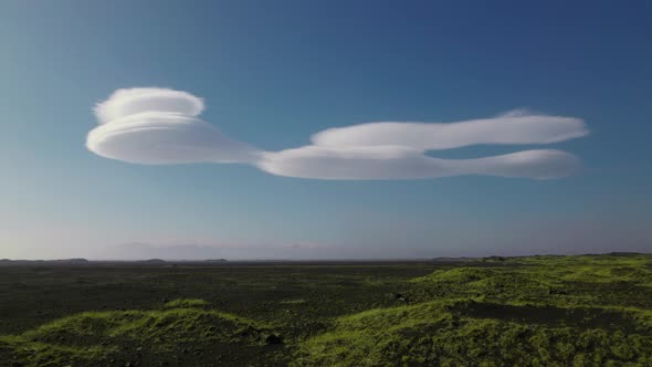 Drone Over Green Landscape Towards Unusual Stratus Clouds In Blue Sky