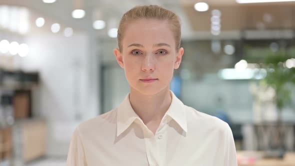 Portrait of Serious Young Businesswoman Looking at Camera