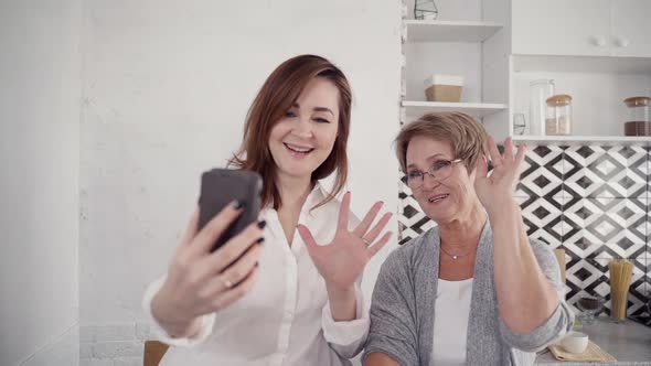 Two Woman Using Smartphone, Making Video Call and Waving By Hand