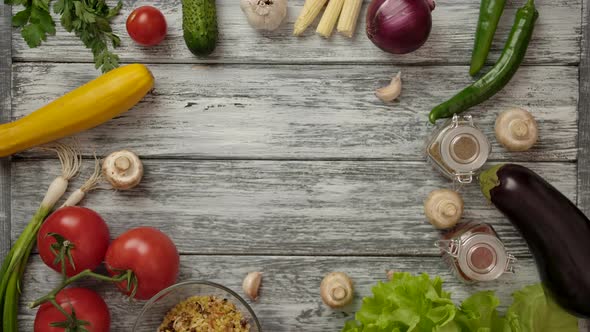 Cook Placing Bowl of Tomatoes on Table with Various Ingredients