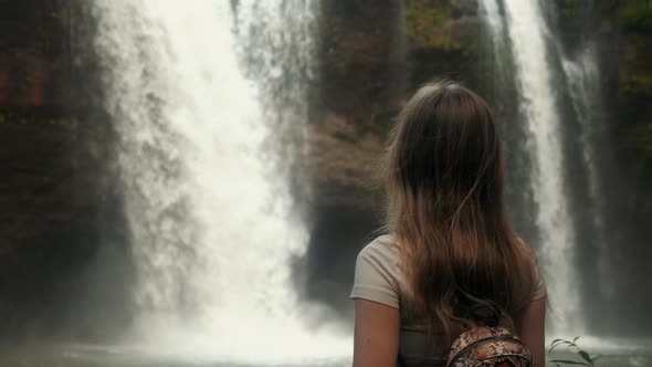 Female Backpacker Tourist Looking at Amazing Waterfall in Jungles Vacation Trip