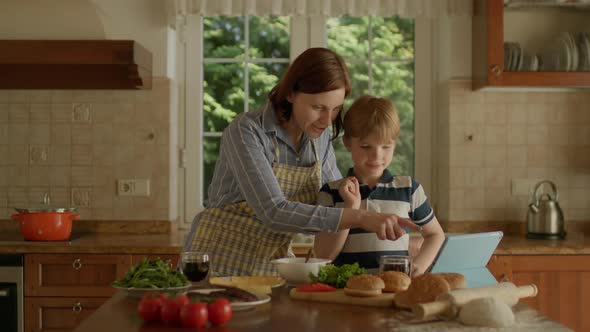 Mother and Son Using Tablet Computer for Online Recipe