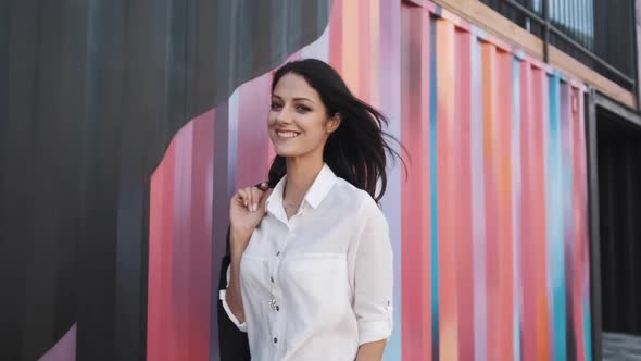 Attractive Girl of European Appearance Walks Down the Street Smiling