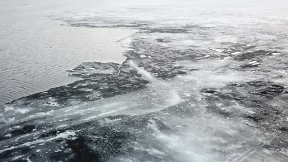 Aerial View Edge of Ice Melt in Winter River Water Surface. Climate Change Concept