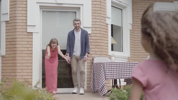 Happy Family Standing on the Porch Together. Mother and Father Greeted Daughter Who Played with