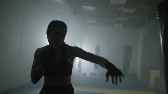 Blurred View of Woman Fighter Trains His Punches and Defense in the Boxing Gym Contour Lighting Slow