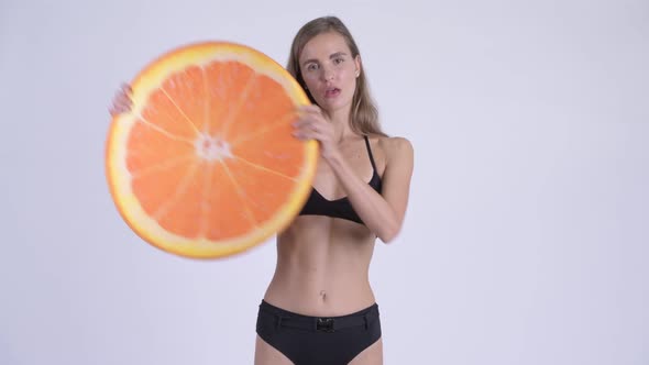 Happy Young Beautiful Woman in Bikini Holding Orange Pillow As Healthy Concept