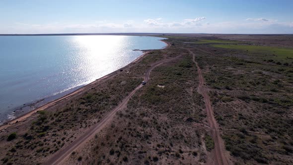 A White Car Drives Along Beach of Lake Balkhash