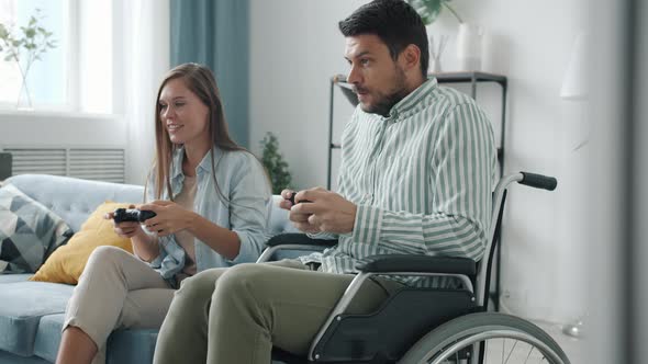 Slow Motion of Physically Impaired Man Playing Video Game with Cheerful Wife Then Doing Highfive