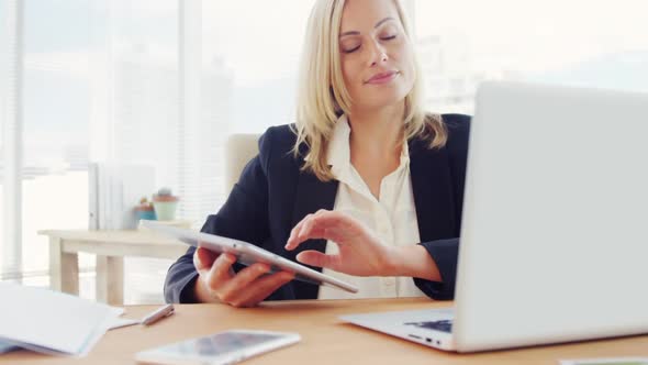 Businesswoman using digital tablet at her desk