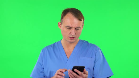 Medical Man Angrily Texting on Him Phone, Green Screen