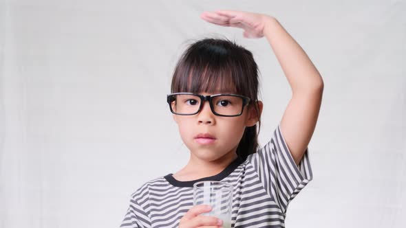 Cute little girl with glass of milk on white background. Healthy nutrition for children.