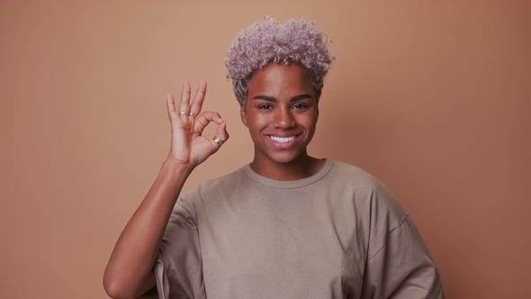 Young African American Woman Shows Gesture of Everything OK Stands in Studio