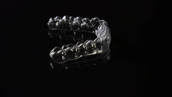 Invisible orthodontics cosmetic brackets on black background. Tooth aligners, for beautiful smile.