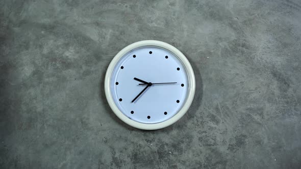 White Office Clock Hangs on a Gray Concrete Wall