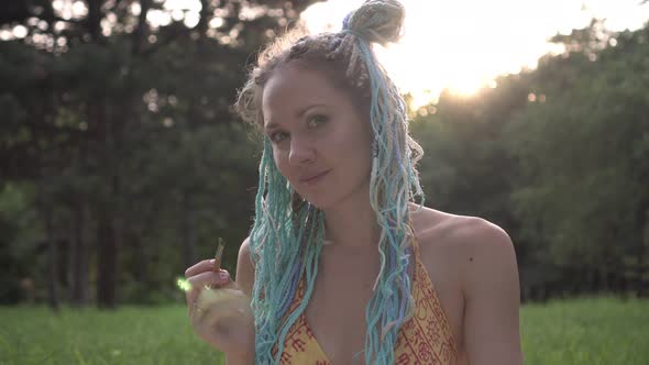 Portrait of a Young Attractive Woman Artist in Nature on a Sunset Background