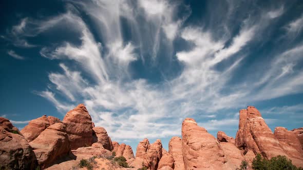 Red rock sandstone fins in the Utah Desert, as clouds move through the sky