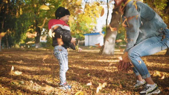 Mom Playing with Son in Autumn Park. Happy Moments Together. Family in the Autumn Park.