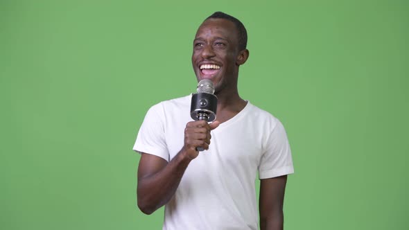 Young Happy African Man Smiling While Speaking on Microphone