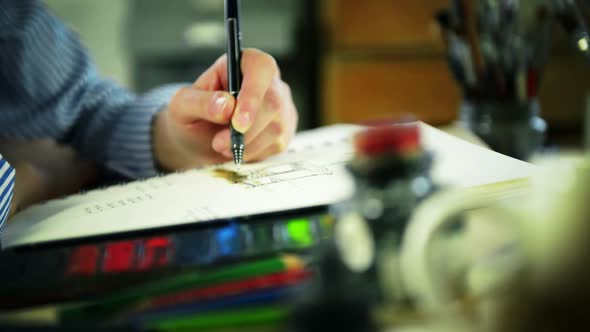 Artist Drawing at Desk