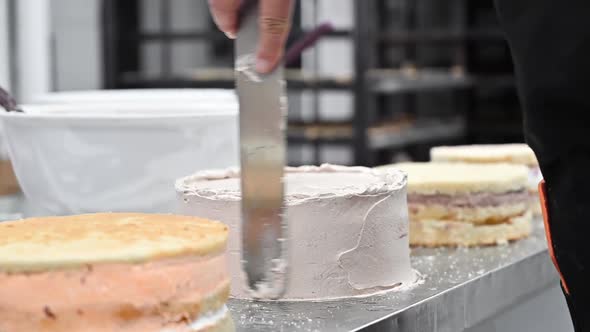 Confectioner Puts Cream To Top of Cake. Baker Smoothing Cake with Whipped Cream Icing at