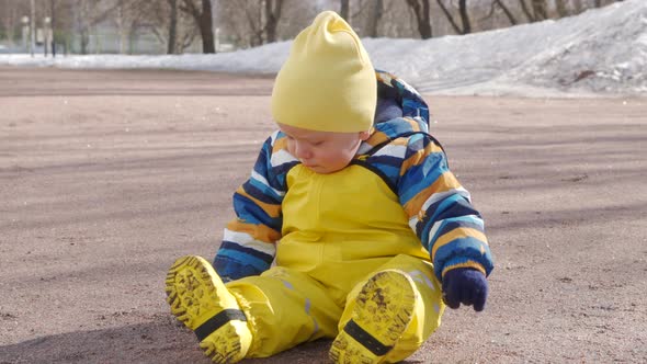 Child in Yellow Waterproof Rain Pants Bibs for Kids on Walk in Cold Season One Year Old Baby Boy