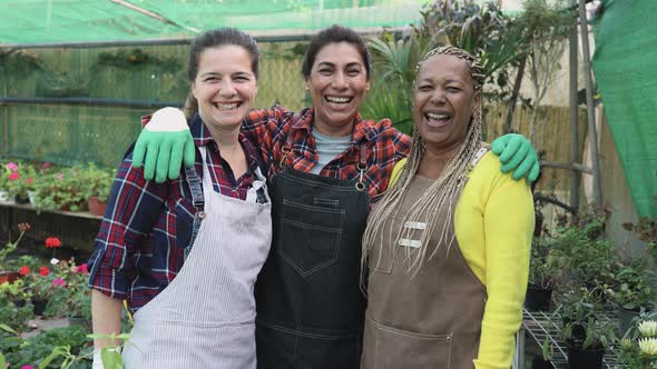 Happy multiracial female gardeners working in flower garden shop