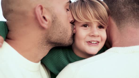 Gay male parents and kid son having tender moment outdoor - Lgbt diversity family concept