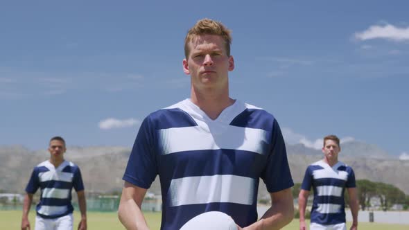 Rugby players standing with ball