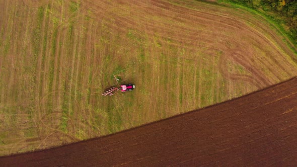 Red tractor working on green farm field