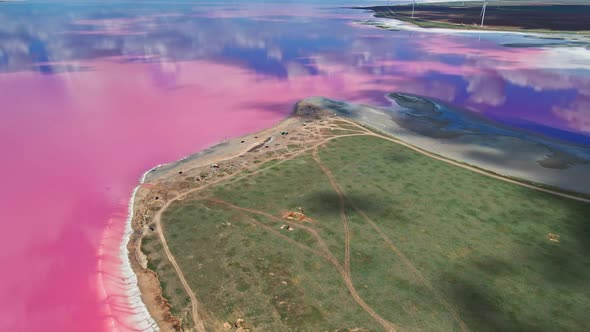 Aerial View on Beautiful Colorful Landscape with Pink Lake Coast and Wind Turbines on Background