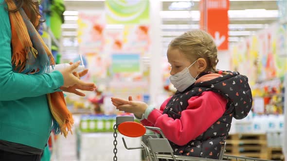 Girl with Mom Applying Antiseptic in Supermarket