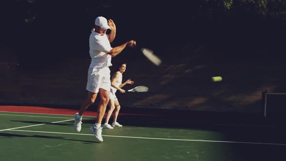 Woman and man playing tennis on a sunny day