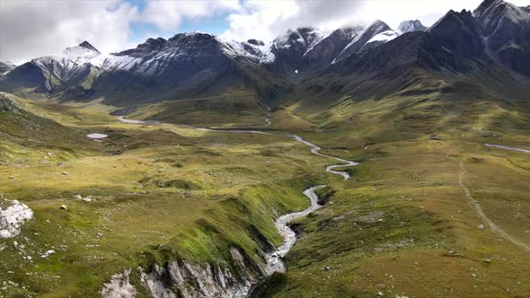 Aerial view of alpine plain with river gorge and mountains in Greina