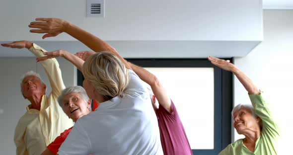 Trainer assisting senior citizens in exercising