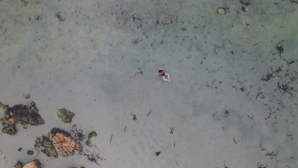 Aerial view of woman swimming in Glencairn pool, Cape Town, South Africa.