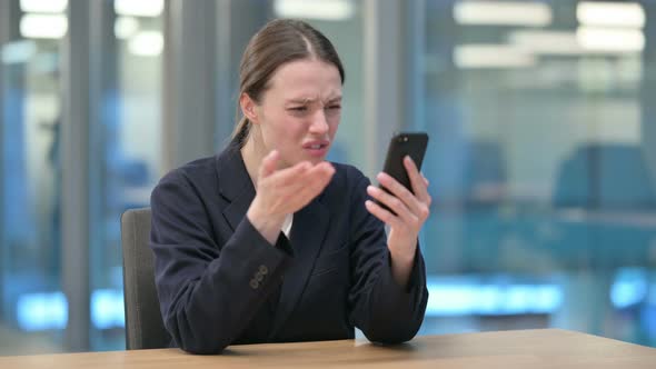 Upset Young Businesswoman Reacting to Loss on Smartphone 